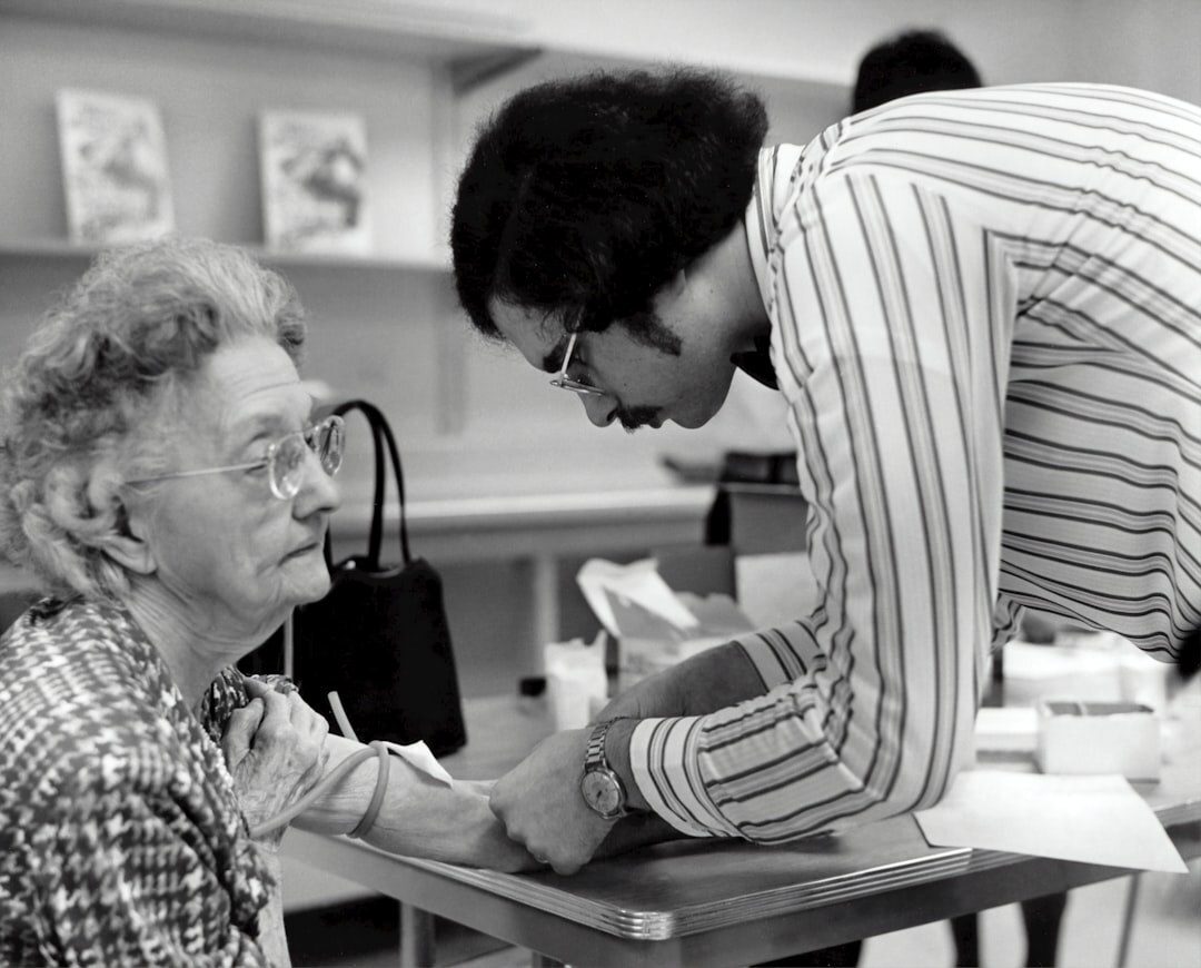 Volunteer helping a senior woman fill out a form at a community desk