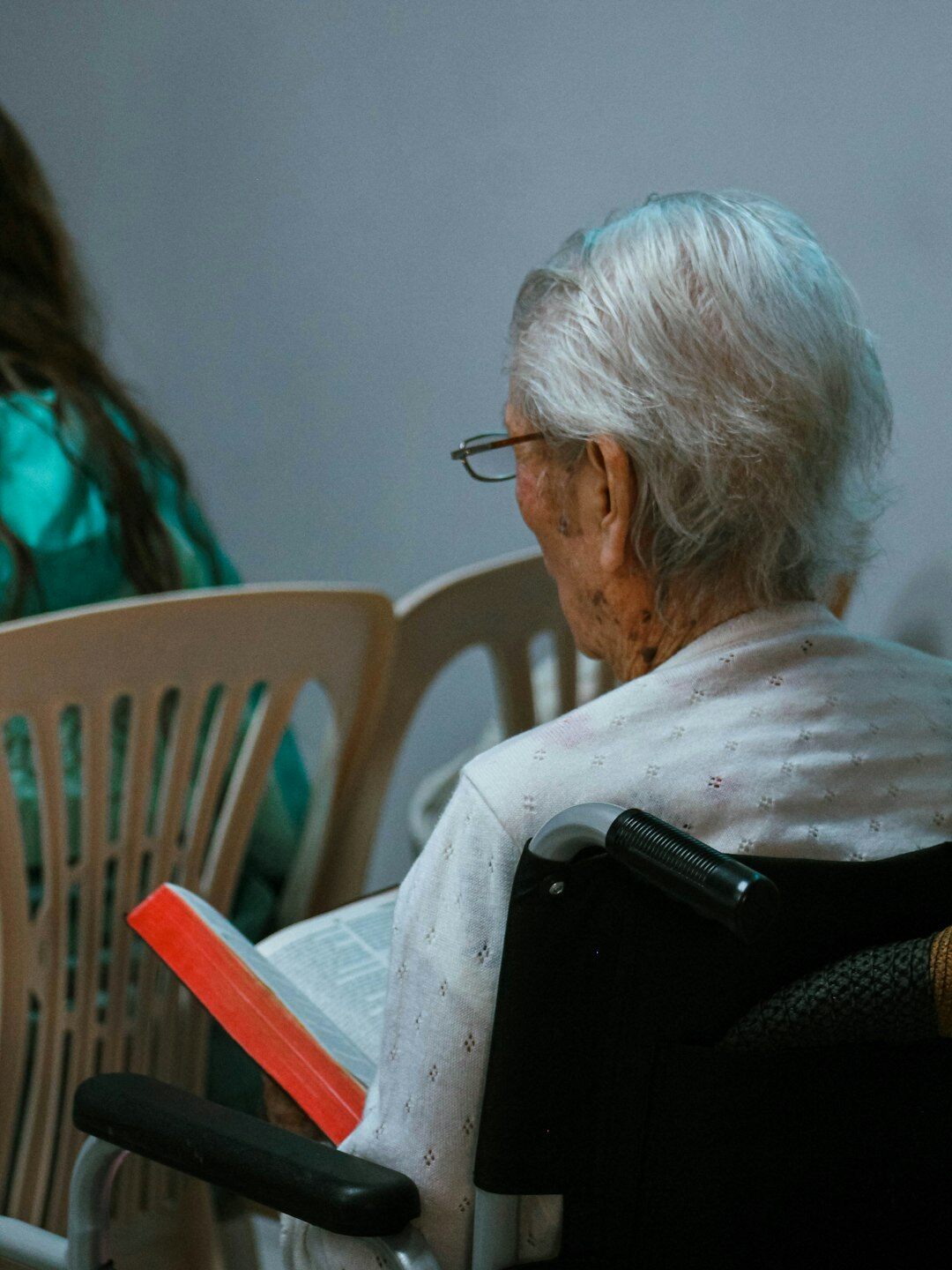 Senior woman learning to use a tablet with help from a younger volunteer