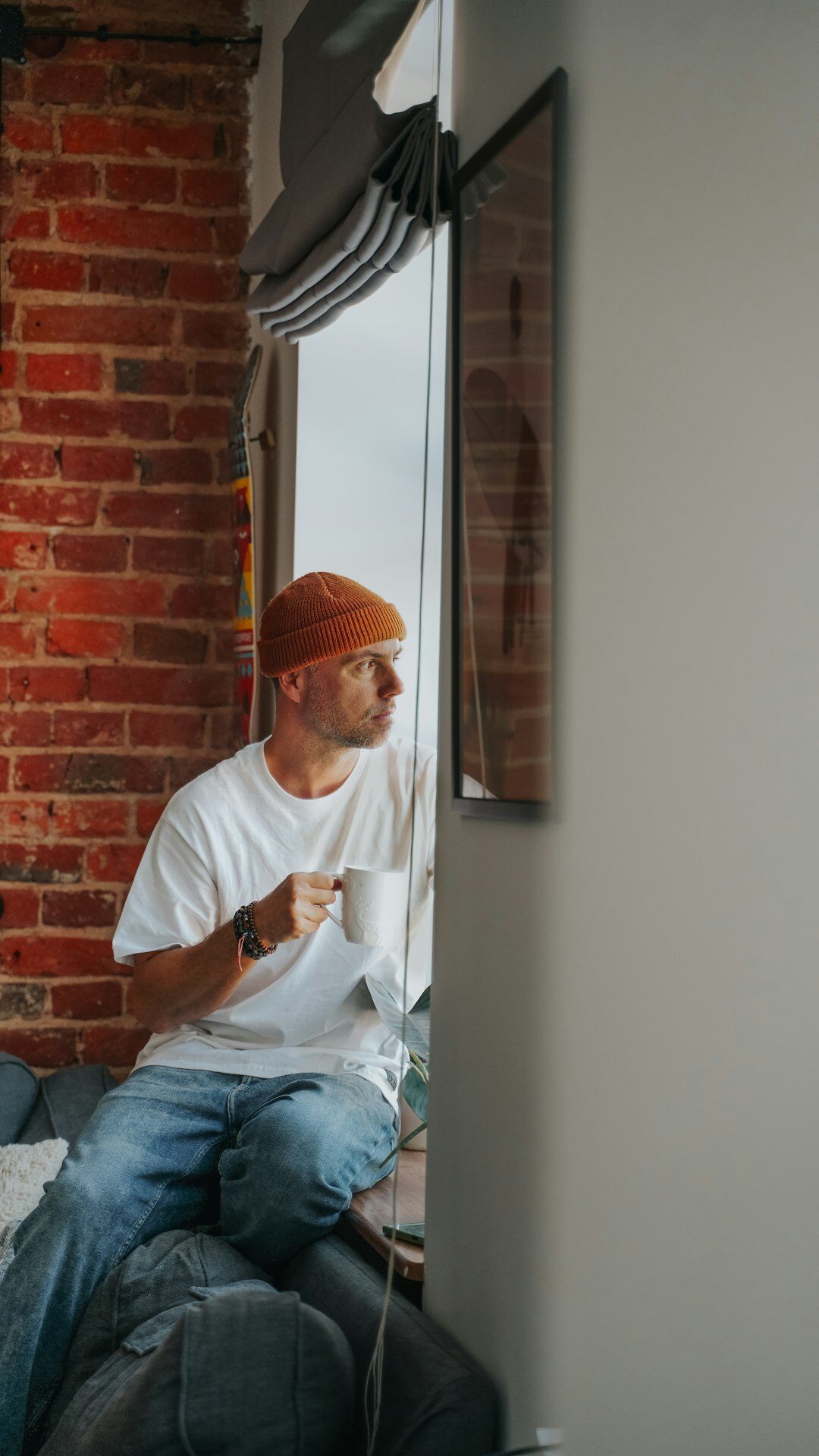 Senior man reading a newspaper at home by the window