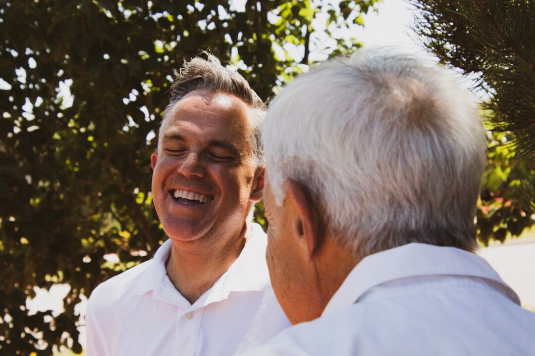 Caregiver assisting an elderly man with a friendly conversation