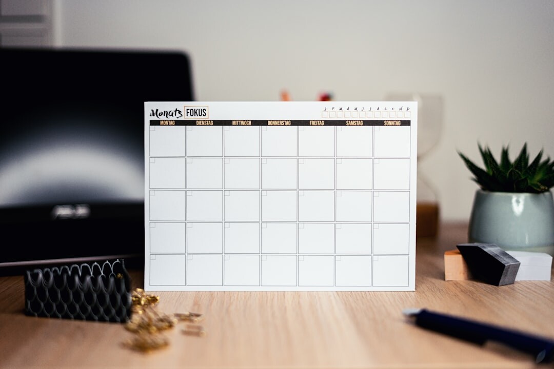 Open paper calendar and planner on a wooden desk with a cup of tea